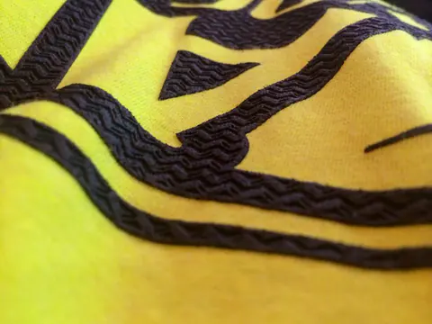 Close view of a high-density screen print on a yellow garment