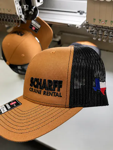 Embroidered trucker cap positioned at production equipment