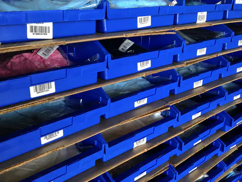 Organized blue inventory bins and cartons inside the warehouse