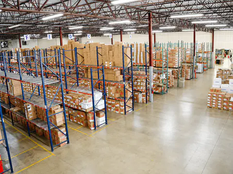 Organized warehouse racks holding cartons and retail display packs