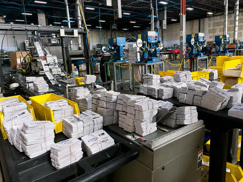 Finishing and packing line surrounded by organized apparel stacks