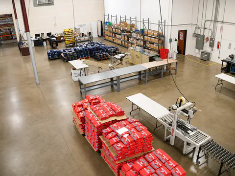 Overhead view of a busy apparel finishing and packing area