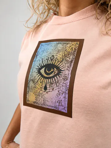 Full-color eye design applied to a peach garment