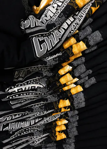 Large stacks of black printed shirts ready for the next operation