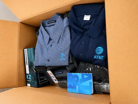 Open branded kit with a polo, accessories, and a gift card