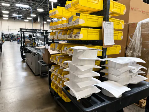 Organized finishing area with yellow bins and staged products
