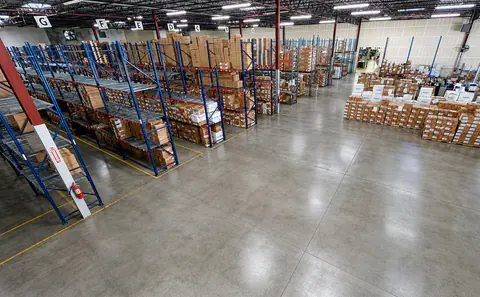 Wide warehouse aisle lined with organized inventory racks